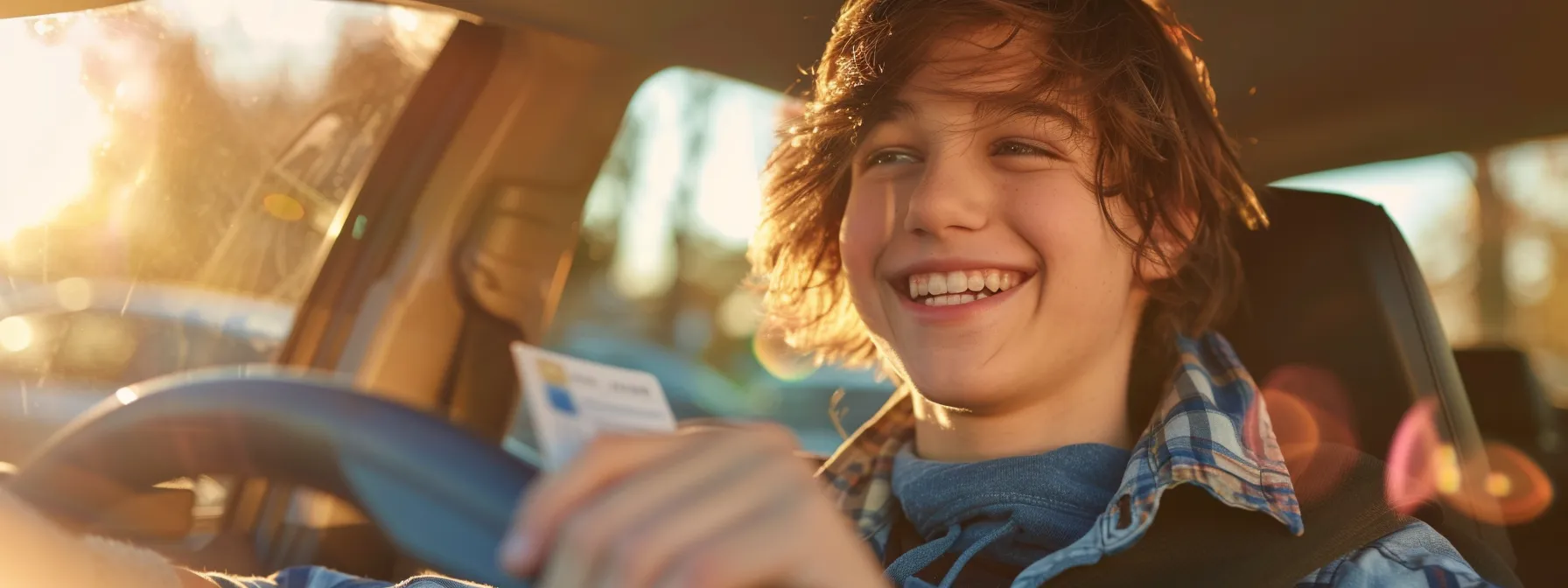 a young person smiling and holding a new driver's license.